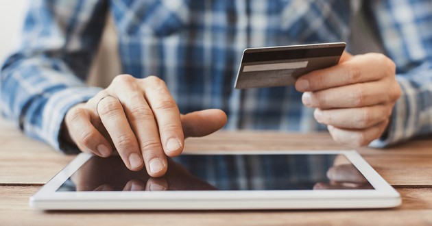 Man at computer with credit card.