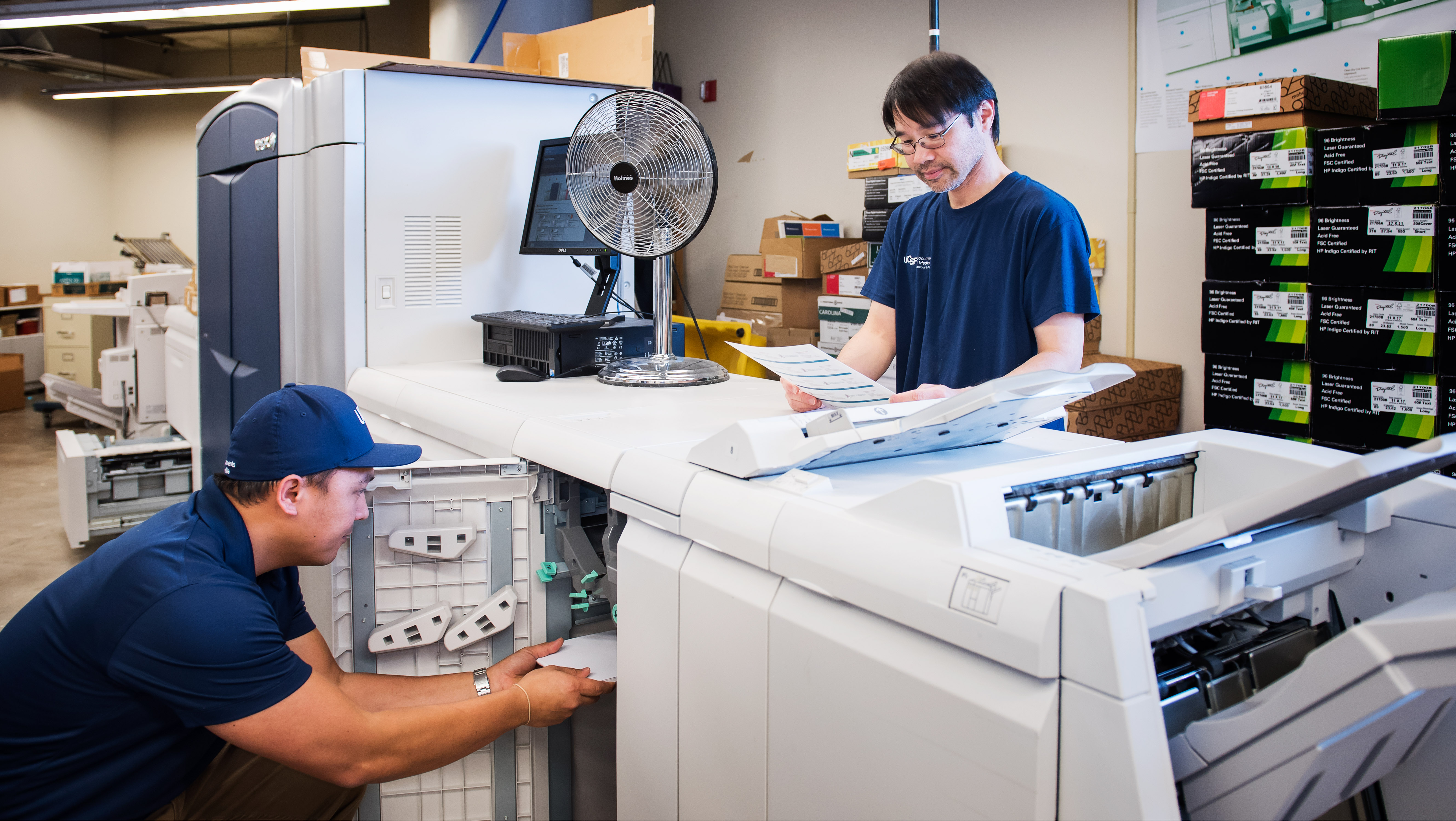 DM employees working on large scale digital printer