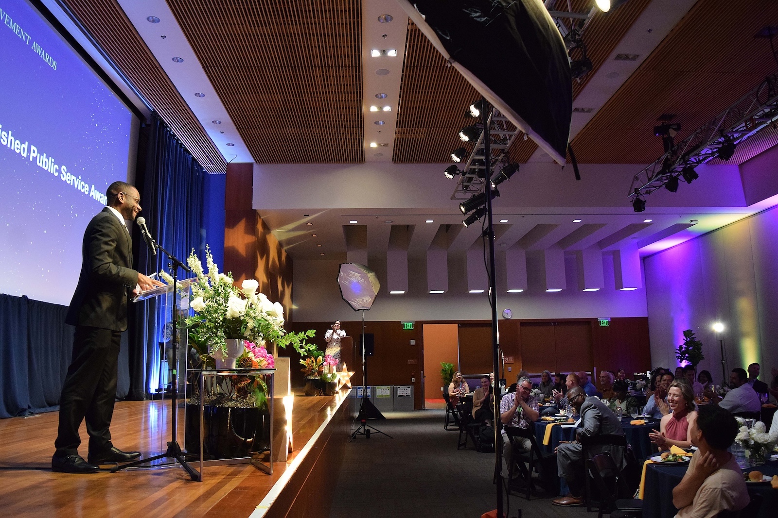 Public Service Award Recipient Paris Reed gives an acceptance speech, audience laughs and claps.