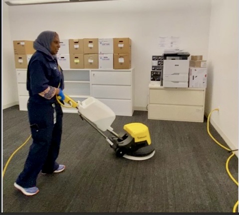 Aydah Madani buffing a floor.