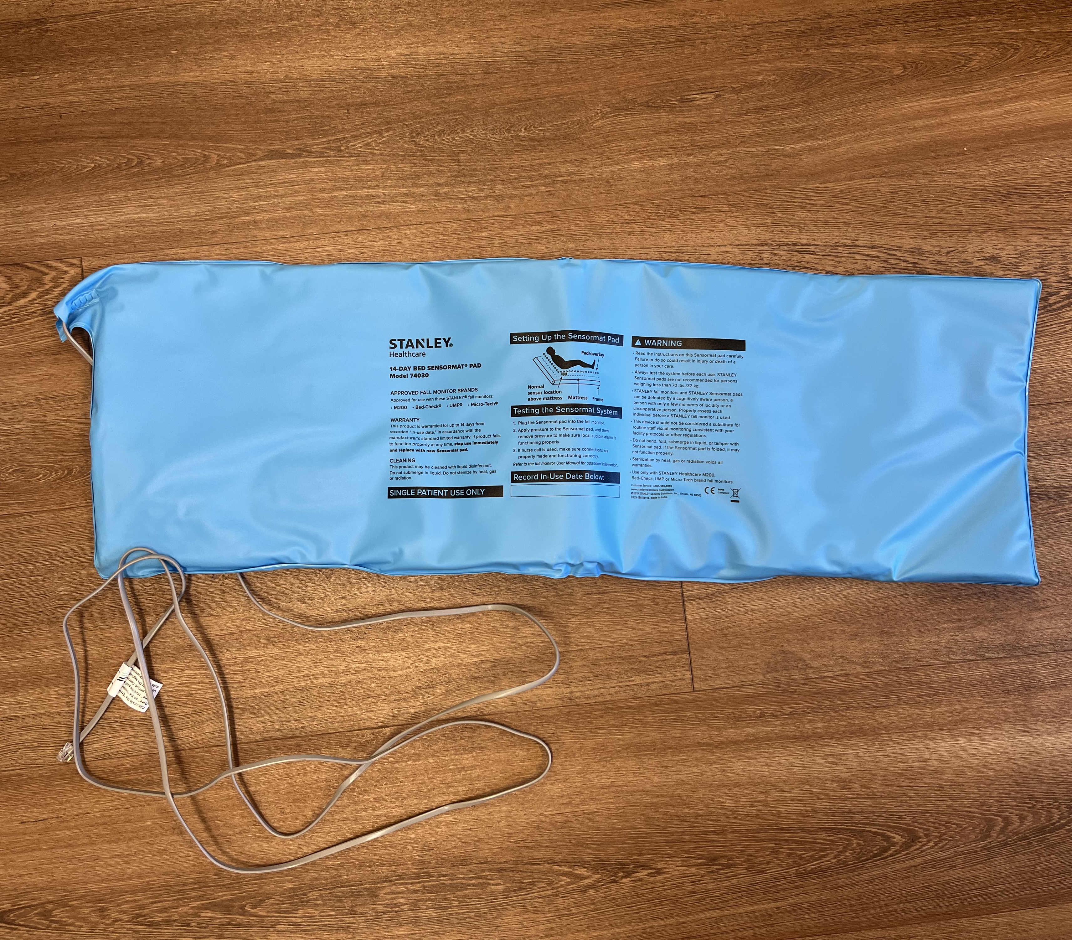 A blue rectangular sensor pad with instructions on the back.