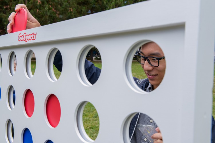 Closeup of CLS community playing a life sized connect four game