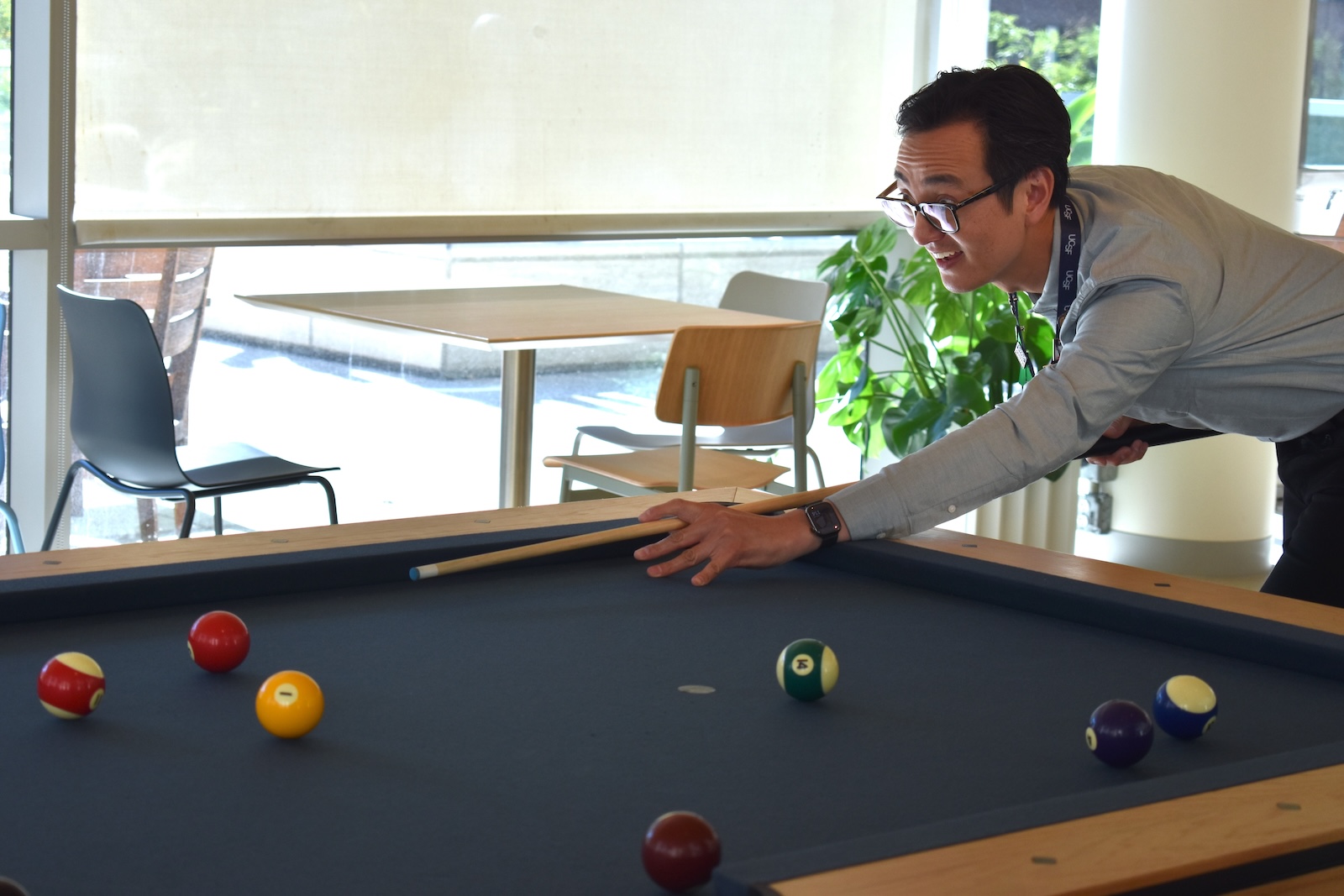 Facilities Manager Michael Hahn plays pool at Cafe 24 Building Connections Event