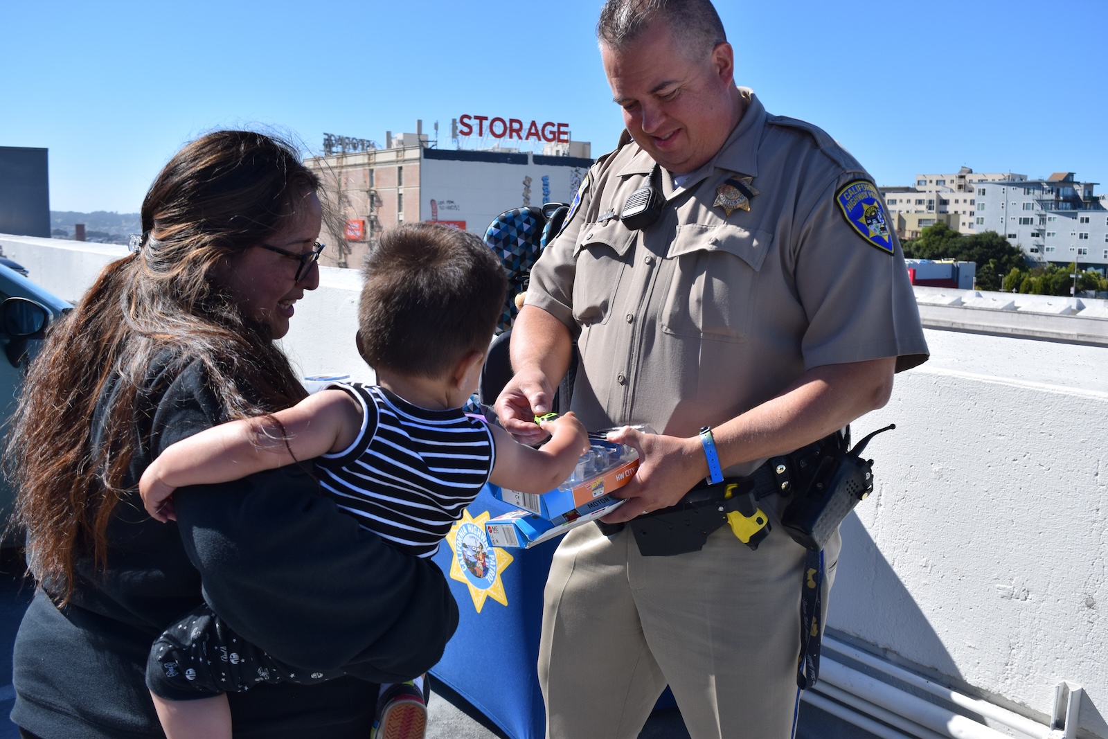 CHP Officer Mark Andrews hands a toy car to Valeria Valeria Pinacho's son 
