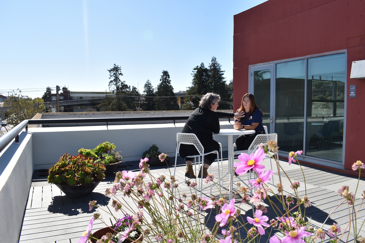 two people sit on the rooftop deck at 654 Minnesota