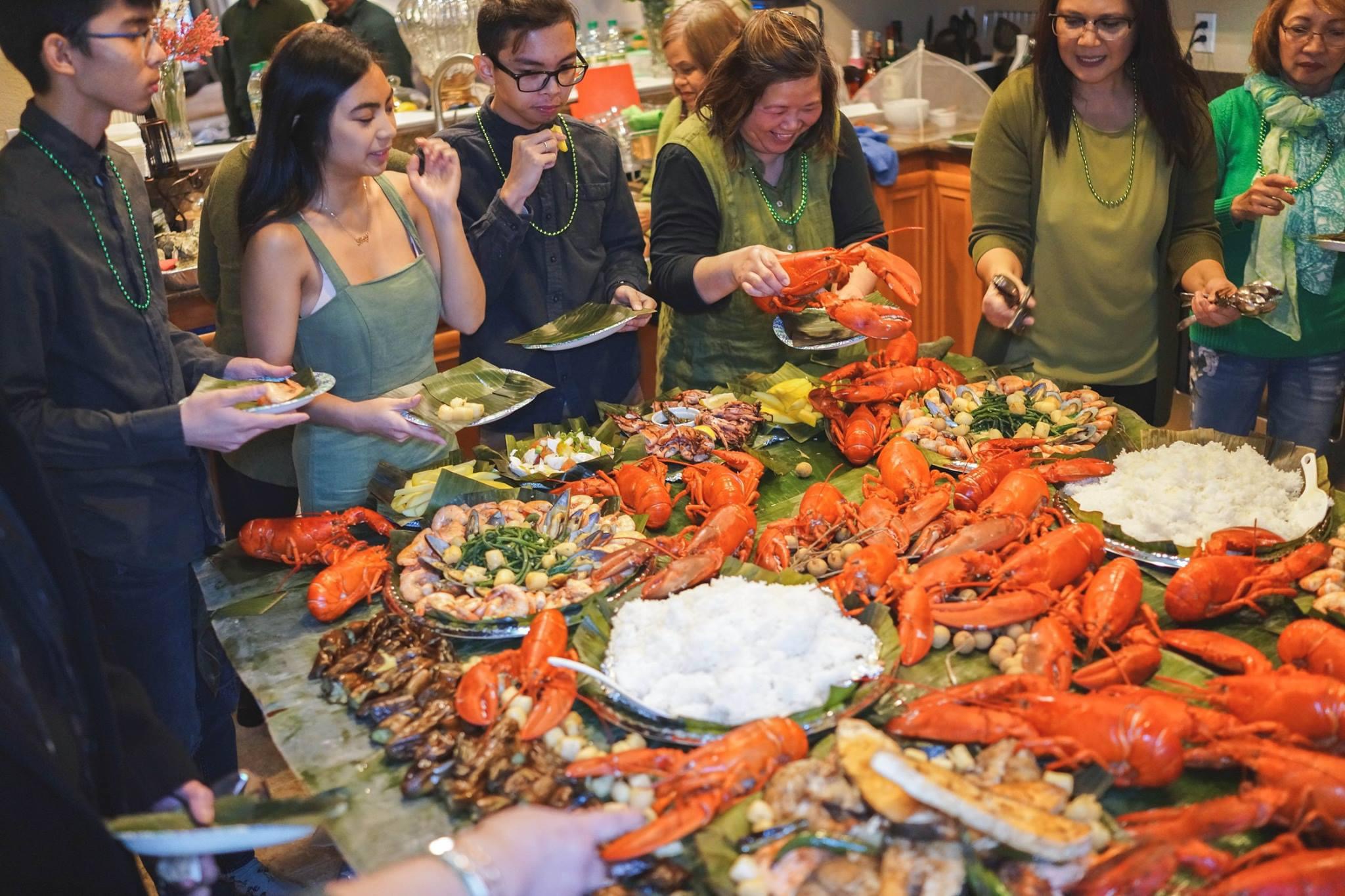 Family gathering in front of a huge feast of lobsters