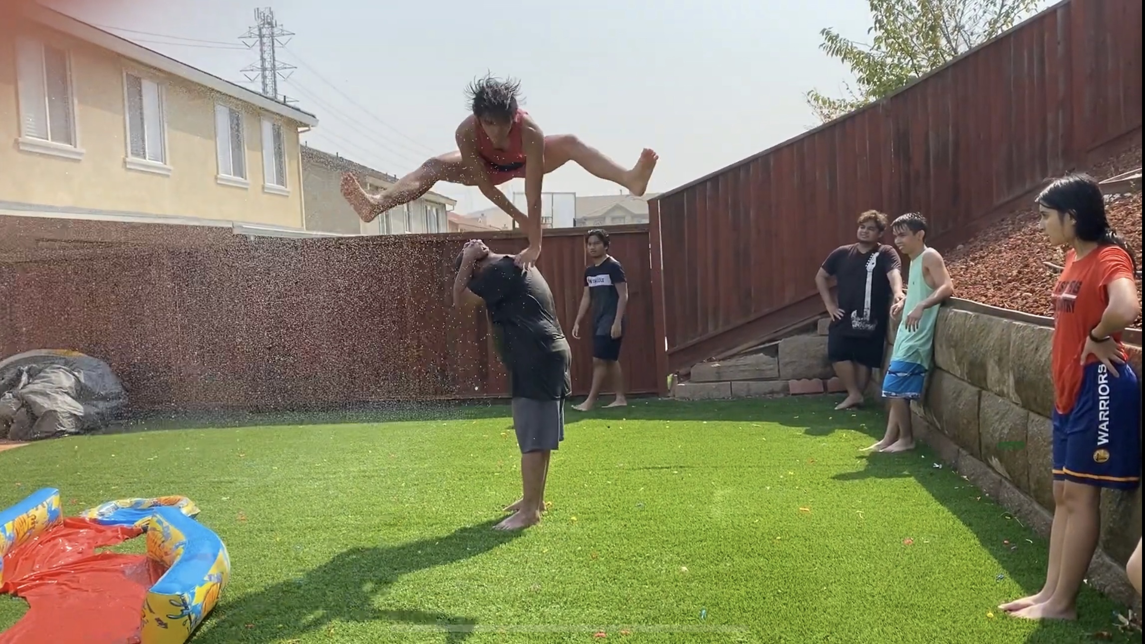 a boy jumps over another person in a filipino street game.