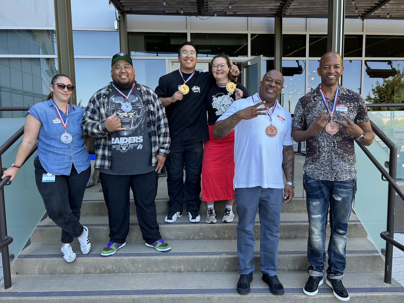  Ganadoras de Cornhole posan con medallas en la celebración 