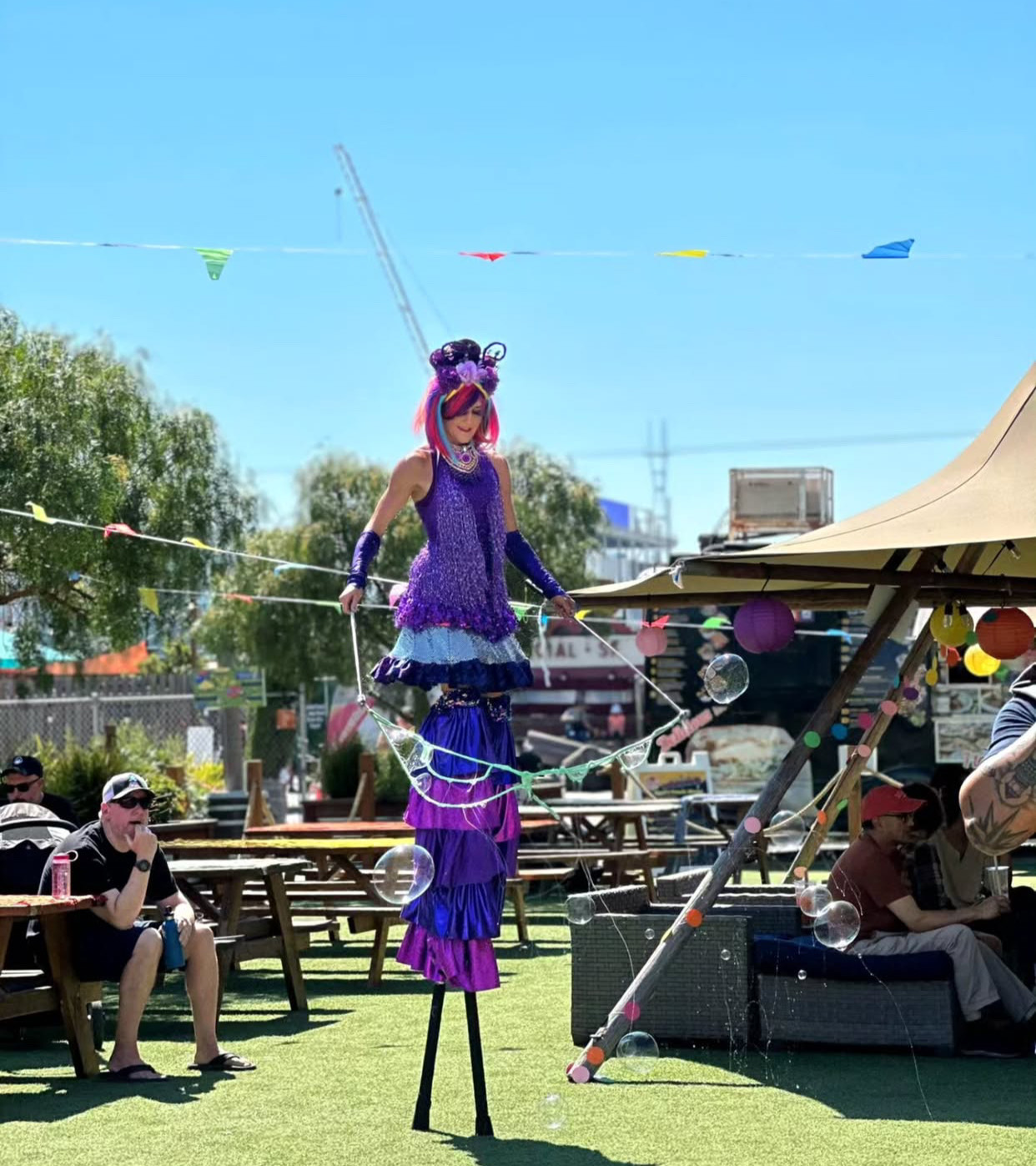 woman walking on stilts with bubbles around her
