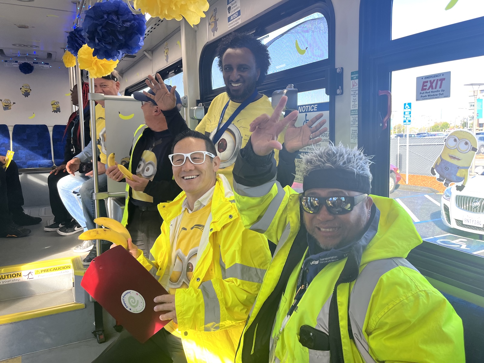 Transportation Services staff dressed in Minion costumes poses on decorated shuttle bus