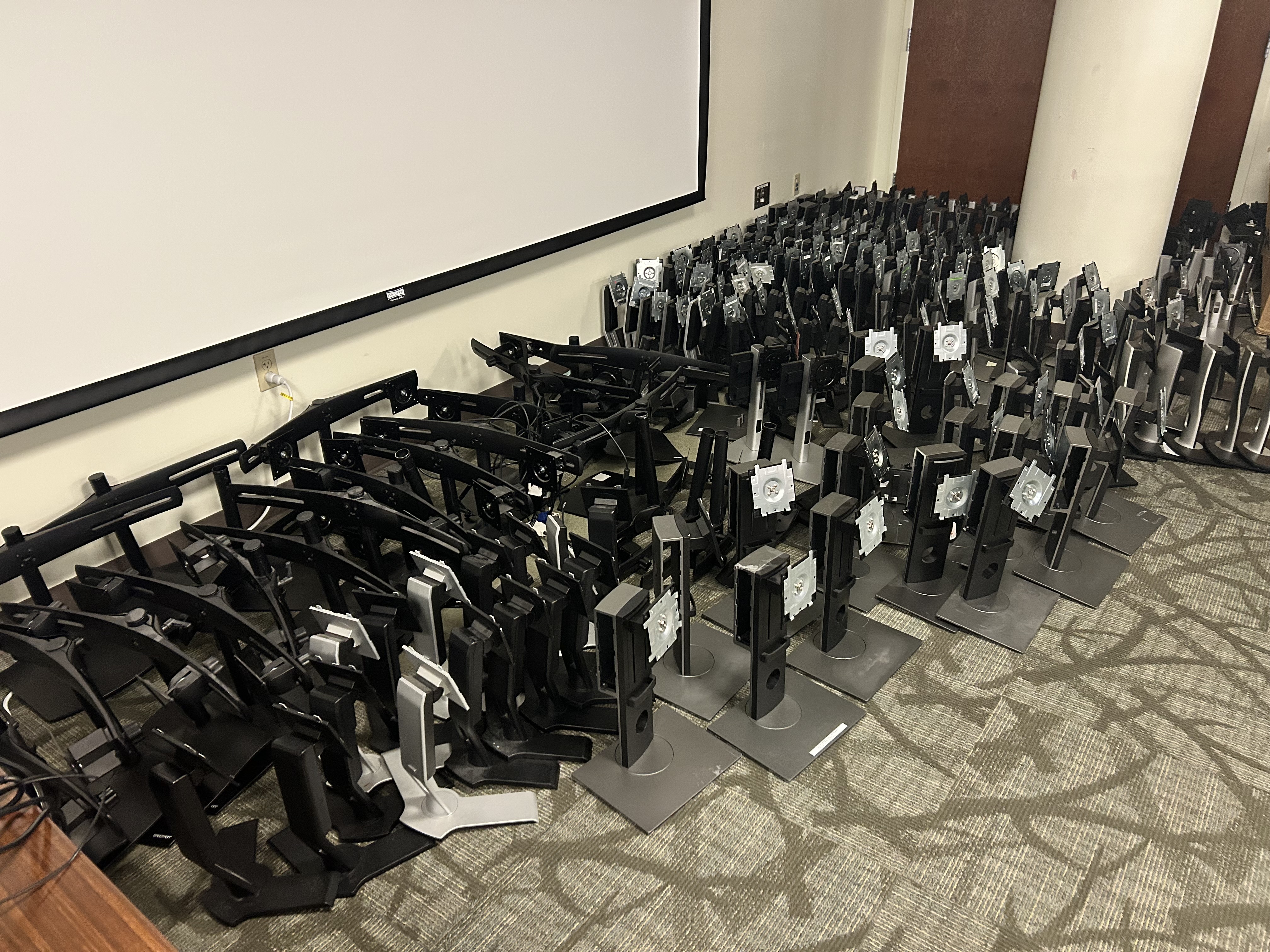 Monitors and stands in rows on carpet