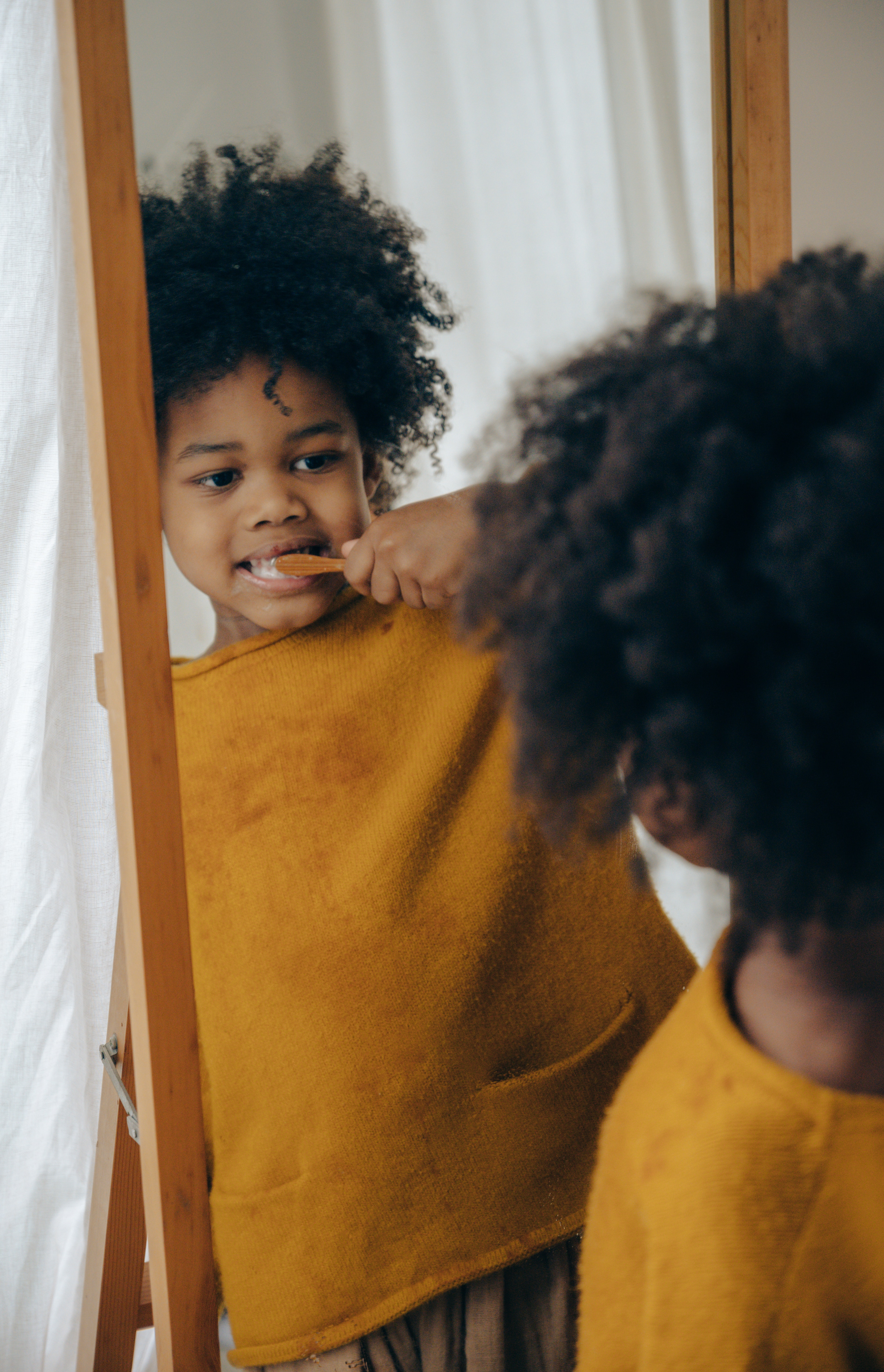 child brushing teeth with a bamboo toothbrush