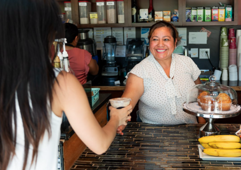 Double Shot Coffee barista serving a customer with a smile