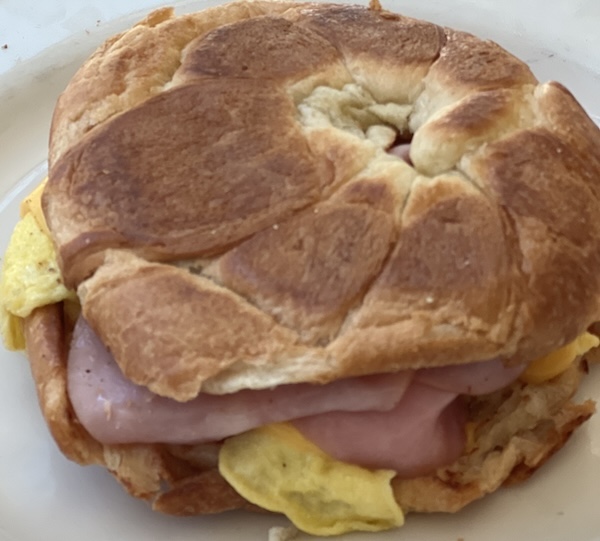 crossaint breakfast sandwich with Canadian bacon, cheese, and egg