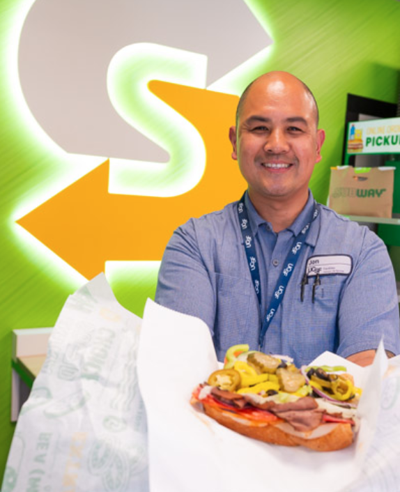 Subway customer showing off a delicious looking sandwich