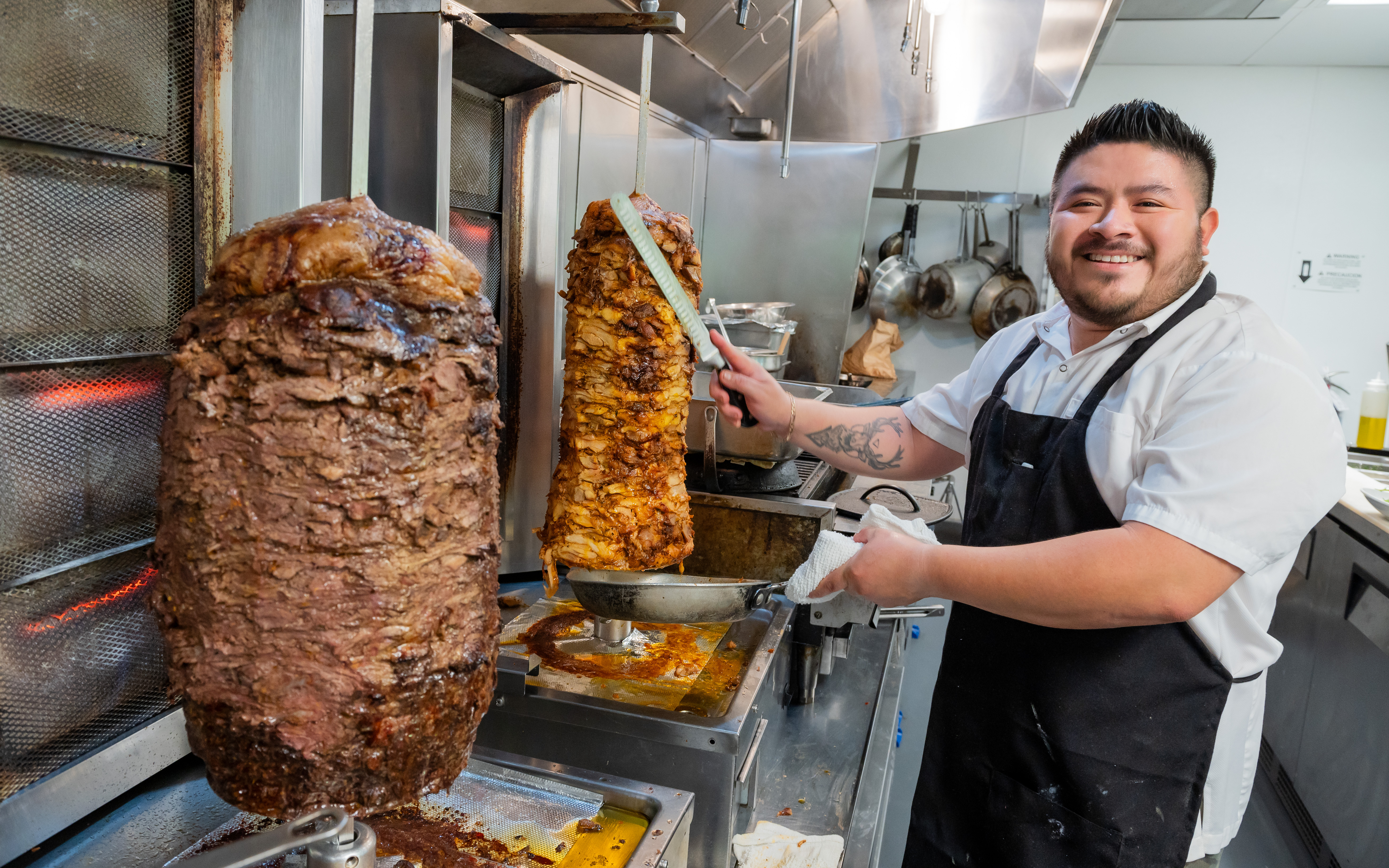 beef and chicken shawarma with person slicing meat off. 
