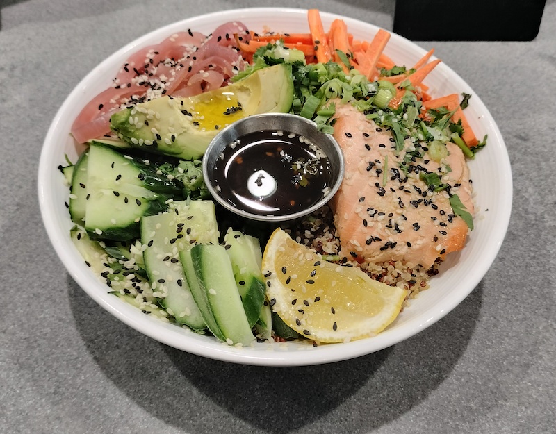 Kings Bowl Salad from Caffe Central Tender poached king salmon, tricolor quinoa, house pickled onions, Persian cucumbers, avocado, organic arugula, julienne carrots and cilantro 