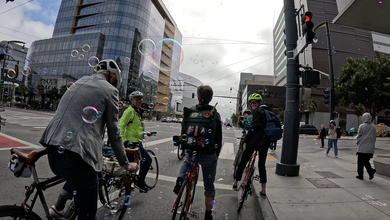 Bikers paused at a red light immersed in bubbles