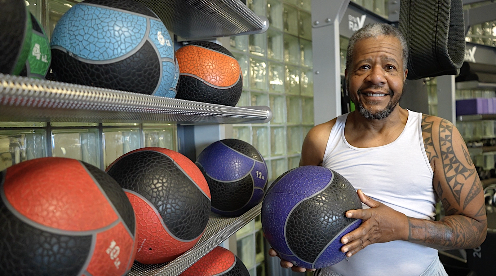 Man stands next to weighted balls