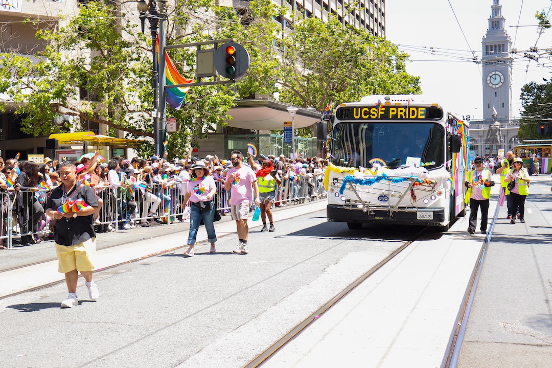 Transportation employees march in front of UCSF Pride bus.