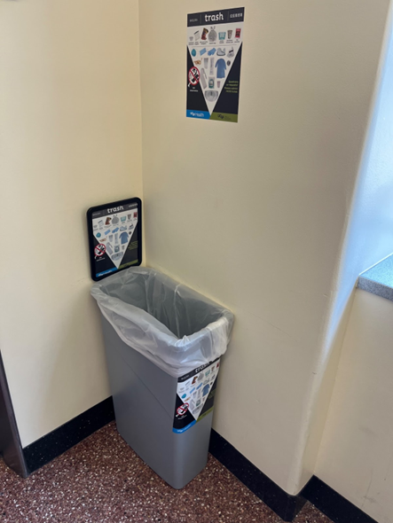 landfill bin with bin signage, a sign holder, and wall signage