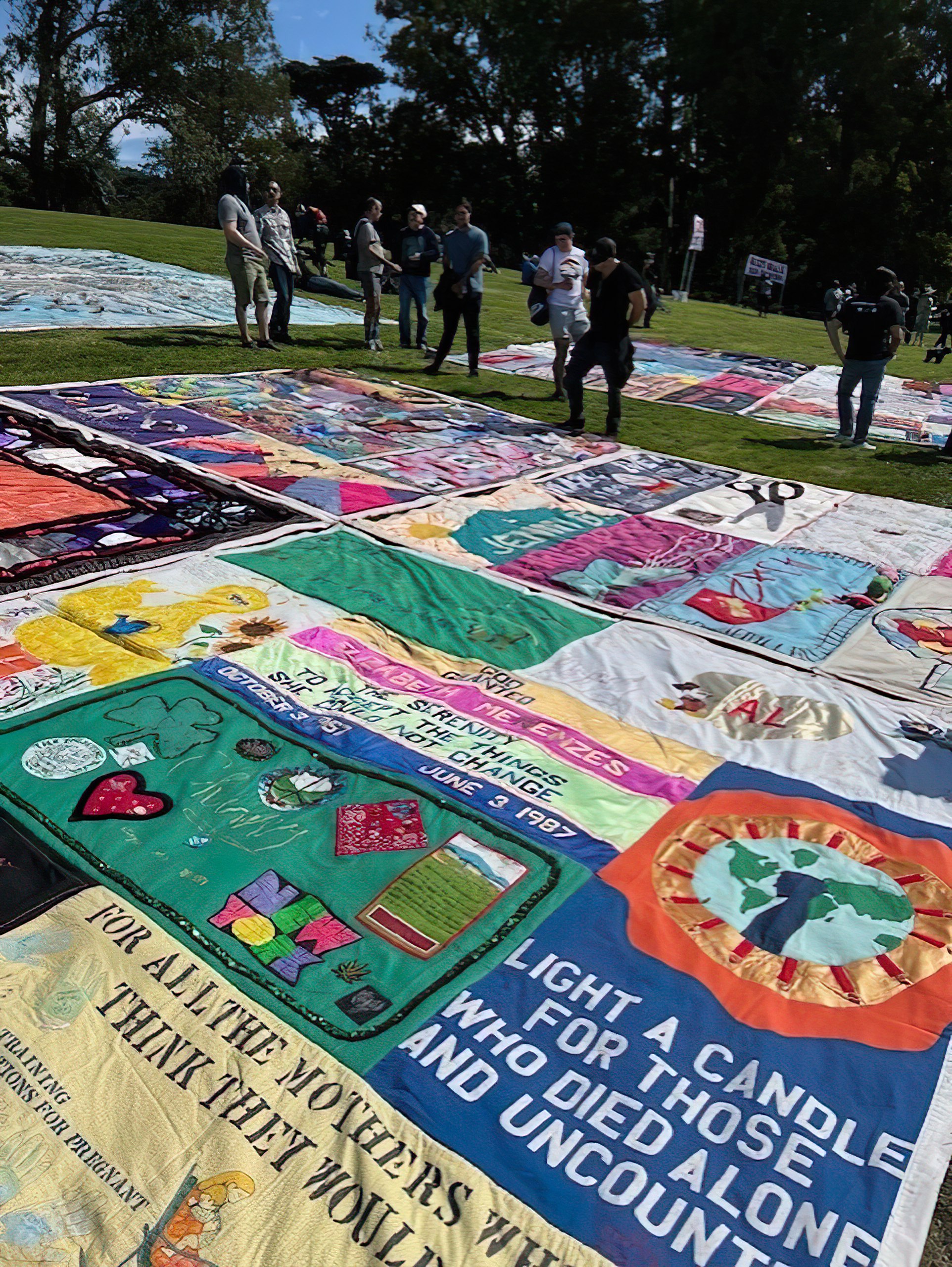 People stand looking at the AIDS Quilt